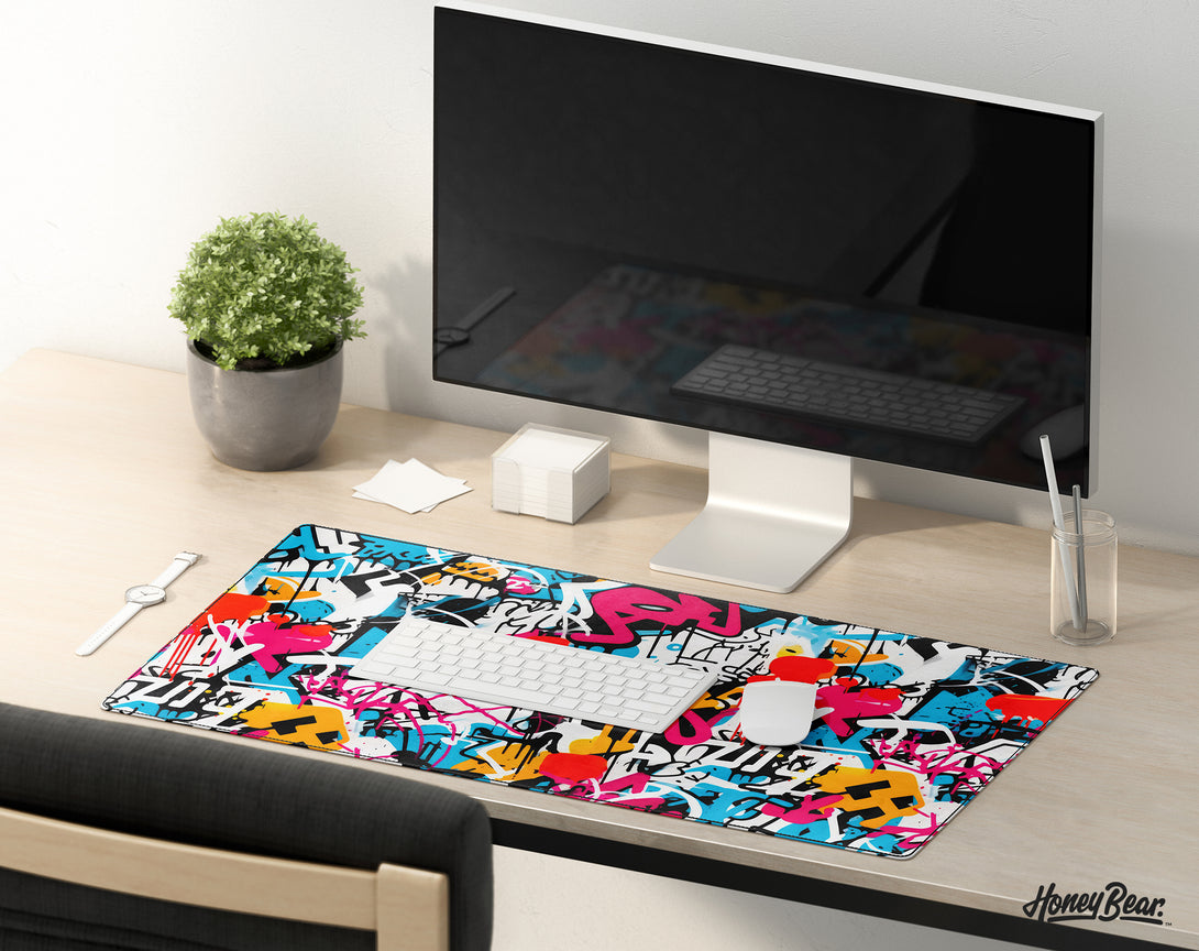 Urban-inspired graffiti art desk mat by Honey Bear, showcasing a colorful array of street art elements and tags, creating a bold statement for any creative workspace