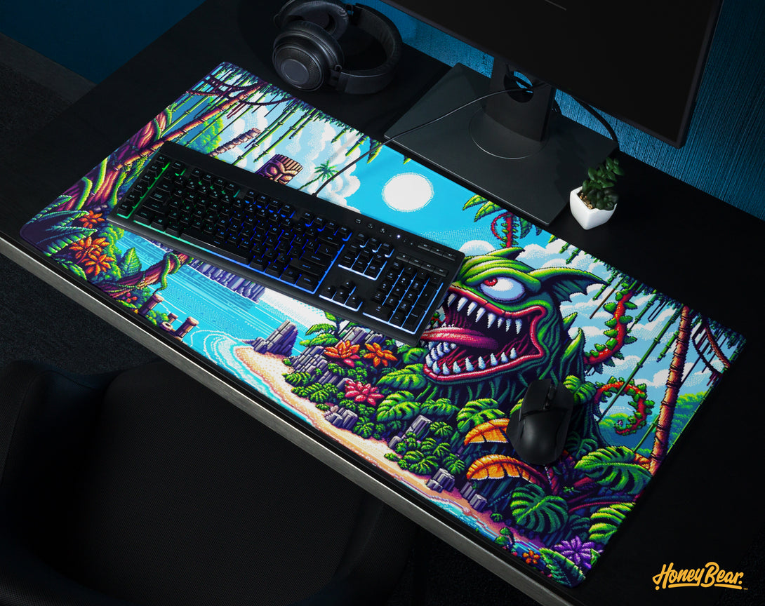 Tropical island themed gaming desk mat by Honey Bear, featuring a vibrant jungle scene with a playful monstrous plant, ideal for an immersive gaming experience