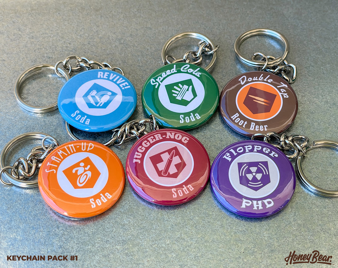 Variety of colorful and detailed perk keychains inspired by classic undead-themed games.